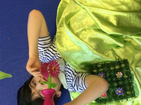 Kind erkundet eine Plastikblume